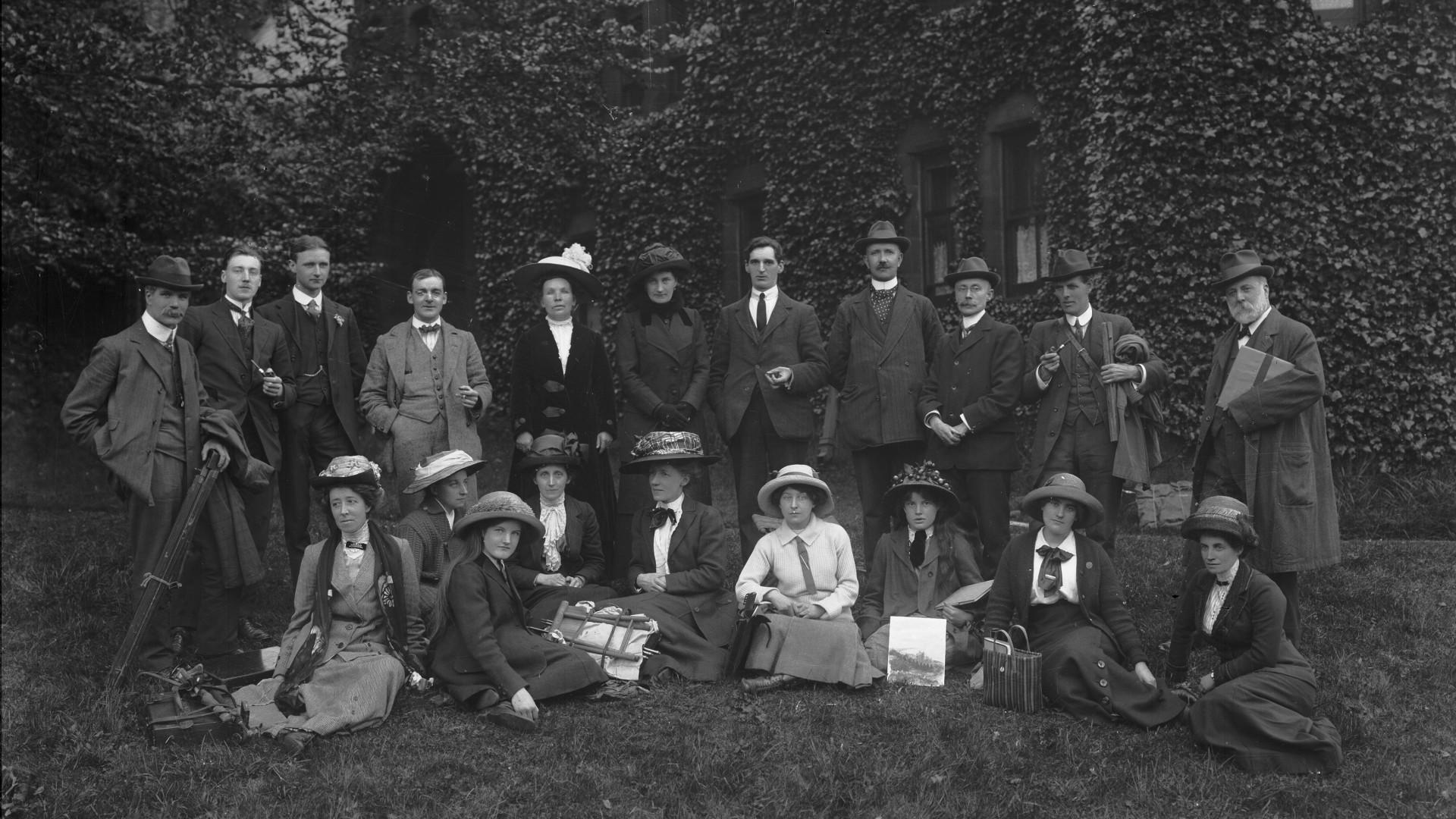 Middle class men and women posing for photograph on a lawn