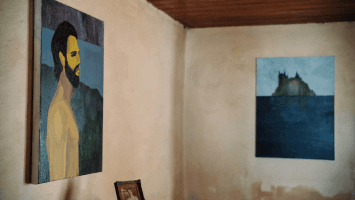 Two pieces of art on display on walls inside exhibition house