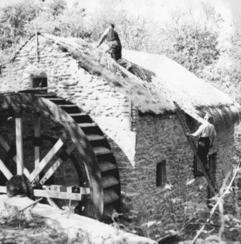 A man thatches a cottage roof at the Ulster Folk Museum, circa mid-1900s.