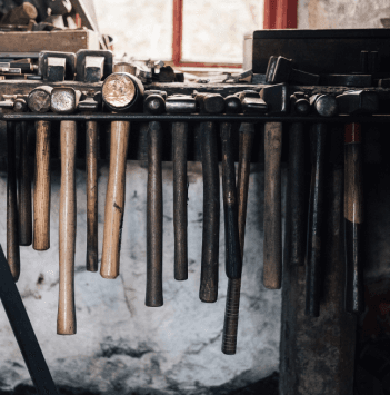 An image of hammers nestled in a holder in a forge.