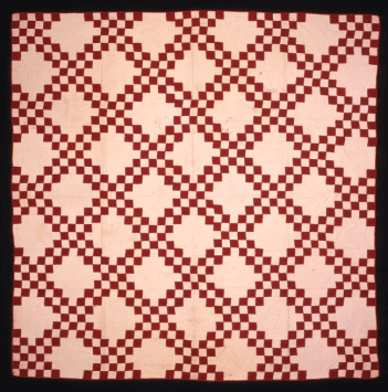 A red and white patchwork quilt with diamond shapes.