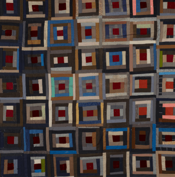 A dark-coloured patterned quilt, with lots of squared patterns.