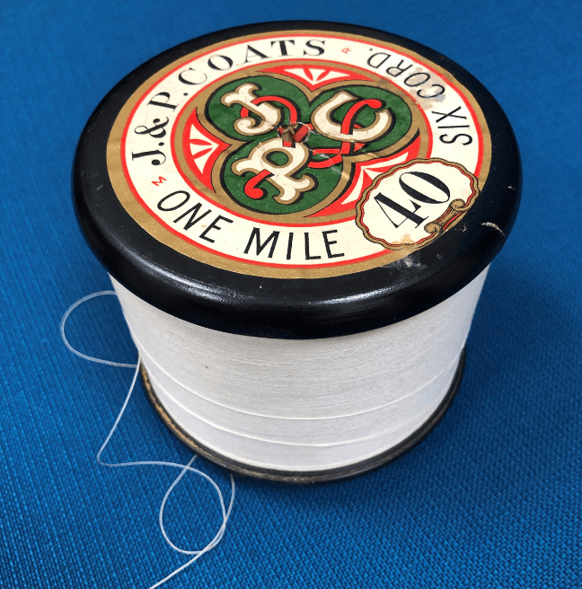 A white spool of thread, with a label reading 'One Mile'.