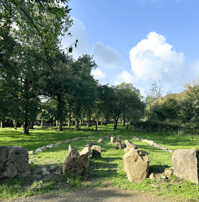 A stone formation sits in a sunny field