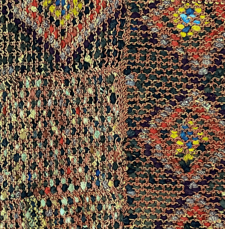 The detail of the back of a rug showing the multicoloured fabric work.